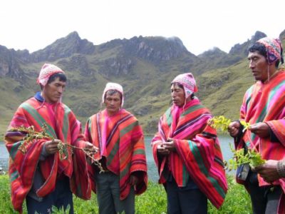 Local men conversing near a lake in the andes mountain wearing native cusquenan clothing. Experience authentic indigenous cultures on a custom Peru tour with Southern Crossings.